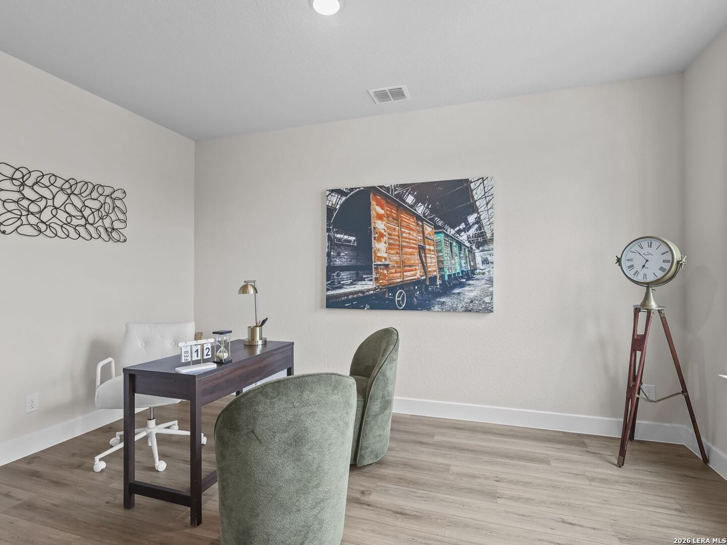 Modern home office with wood desk and green chairs in The Belmont H floor plan at Potranco Oaks, Castroville, Texas.