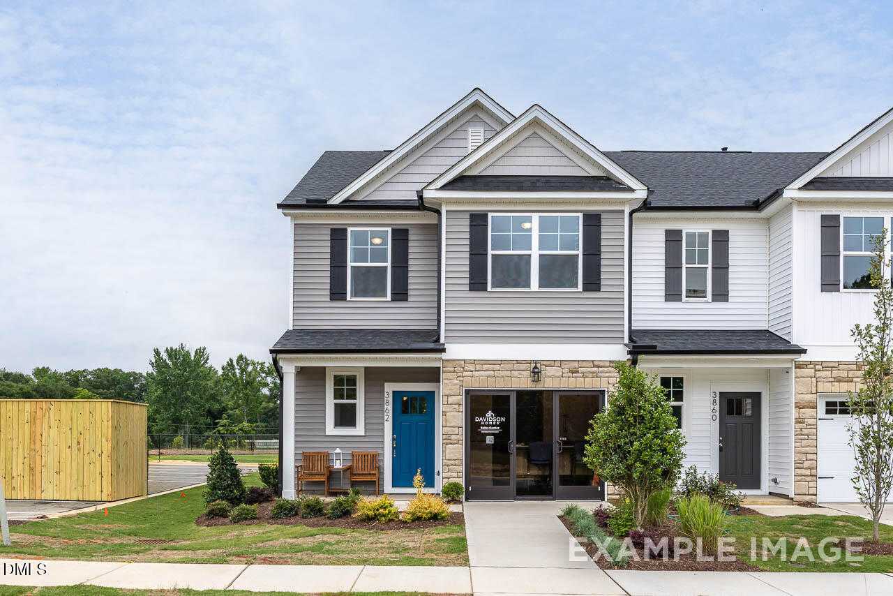 Modern 2-story Graham Exterior home with gray siding, blue door, stone accents, and front porch in Springvale, Fuquay-Varina, NC