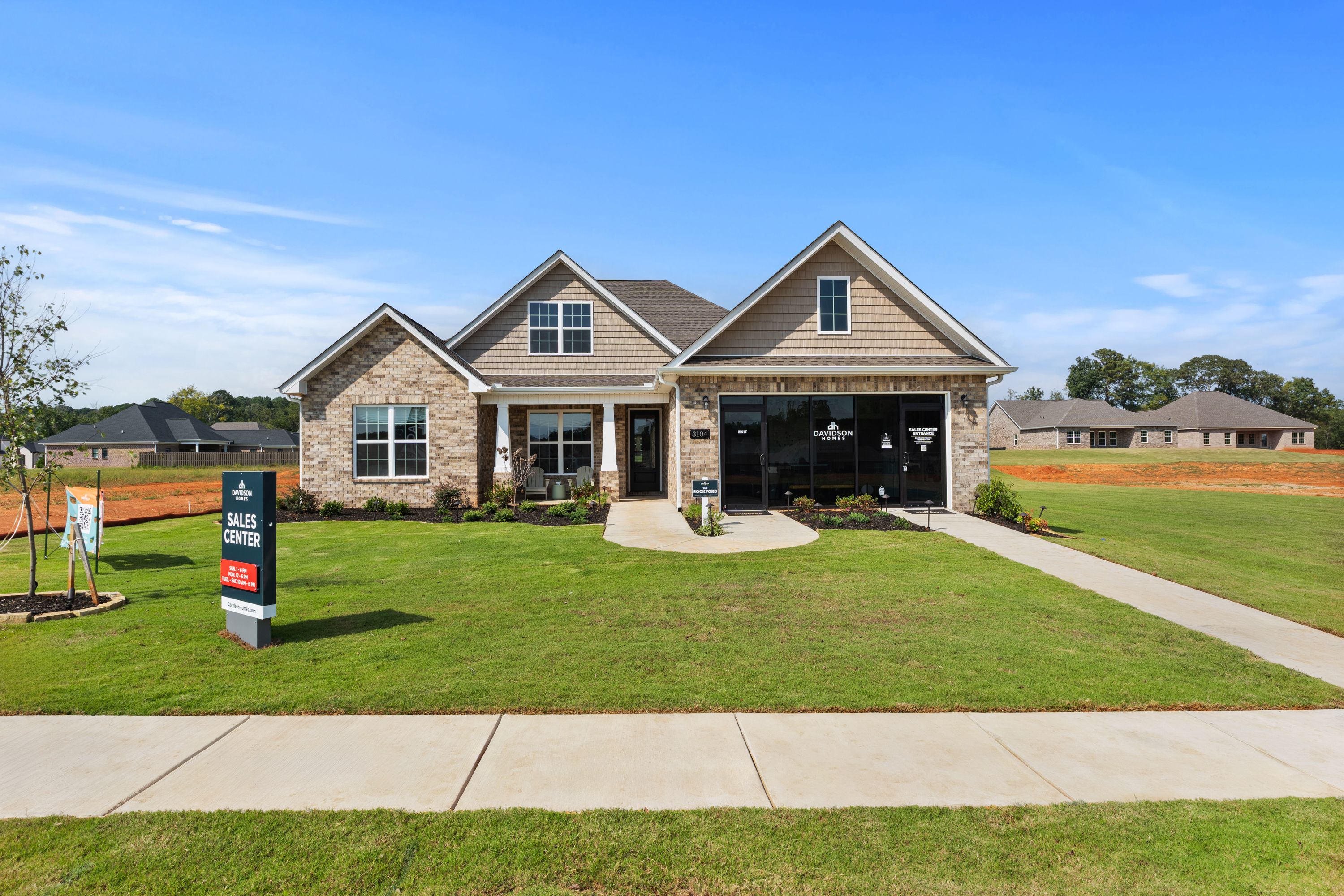 Modern ranch-style home exterior at River Road Estates in Decatur Alabama by Davidson Homes with brick accents covered porch and lush green lawn
