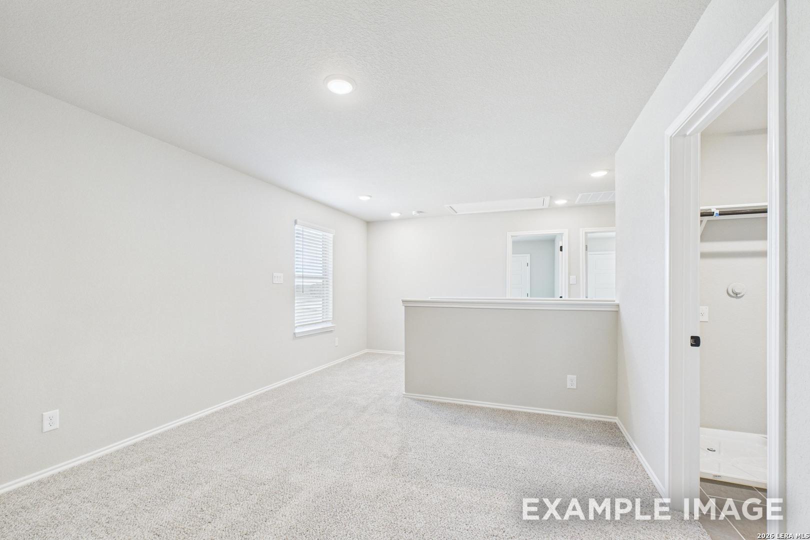 Spacious carpeted game room in The Charlotte B floor plan by Davidson Homes at Cedar Heights in San Antonio, Texas.