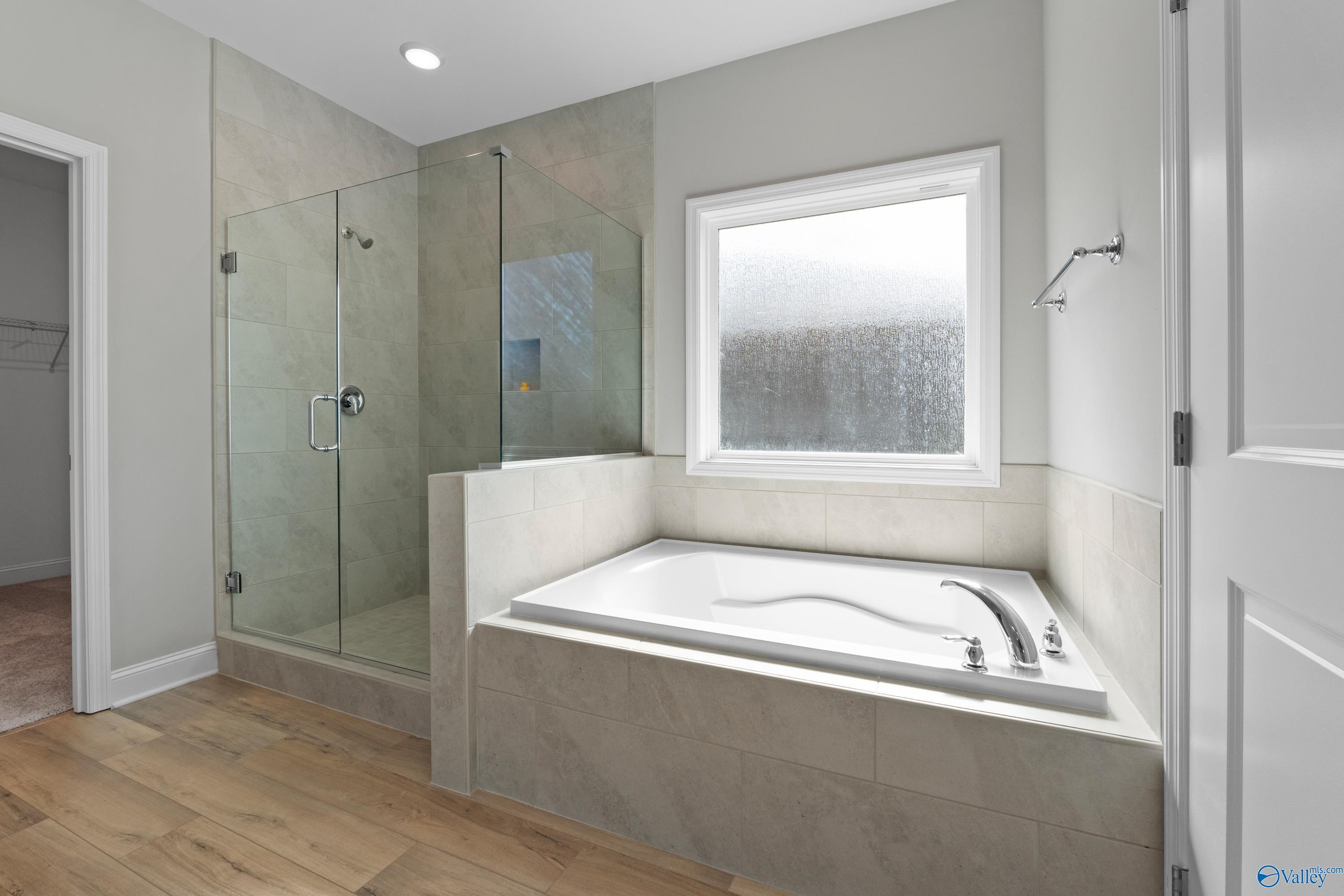 Elegant master bathroom with frameless glass shower and soaking tub in Davidson Homes The Everett B, Toney, Alabama