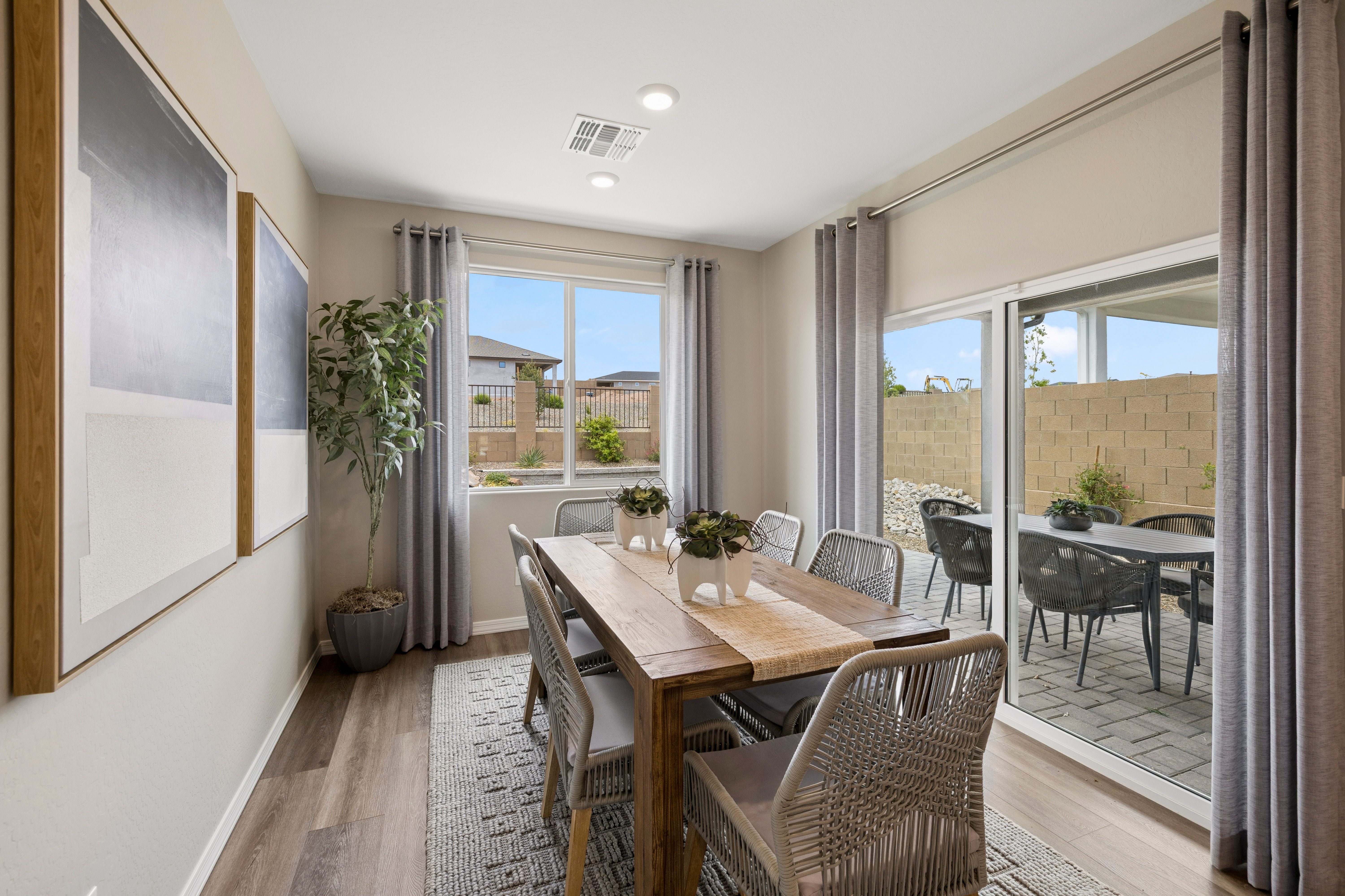 Modern dining room in South Ranch Destination Collection Prescott AZ with wooden table rattan chairs sliding doors to patio