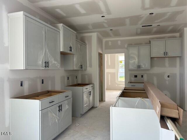 Kitchen under construction with white cabinets and island in Davidson Homes The Ash C floor plan, Lillington, North Carolina
