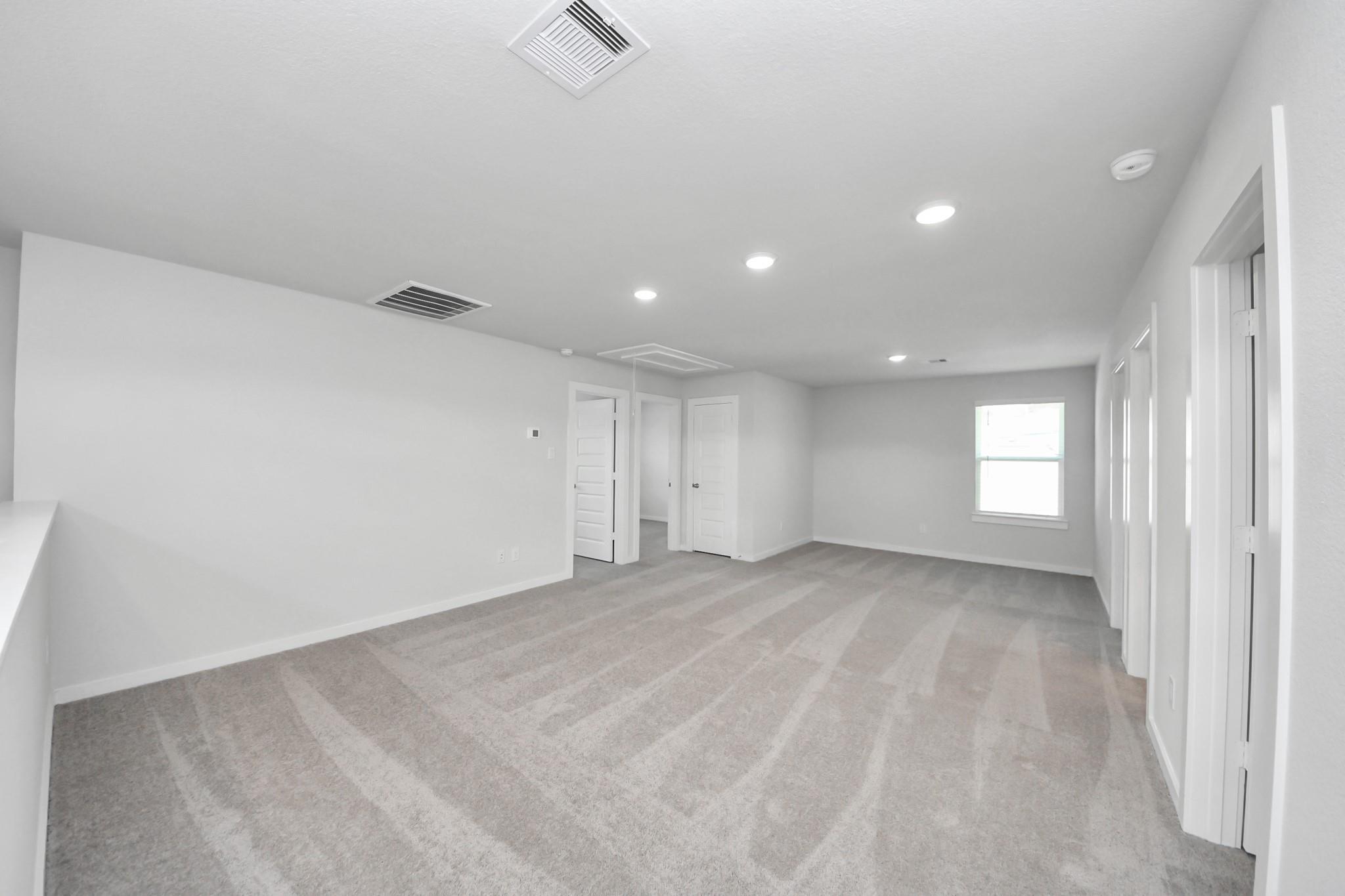 Spacious carpeted game room in The Brazos F floor plan at Liberty Estates, Cleveland, Texas by Davidson Homes.