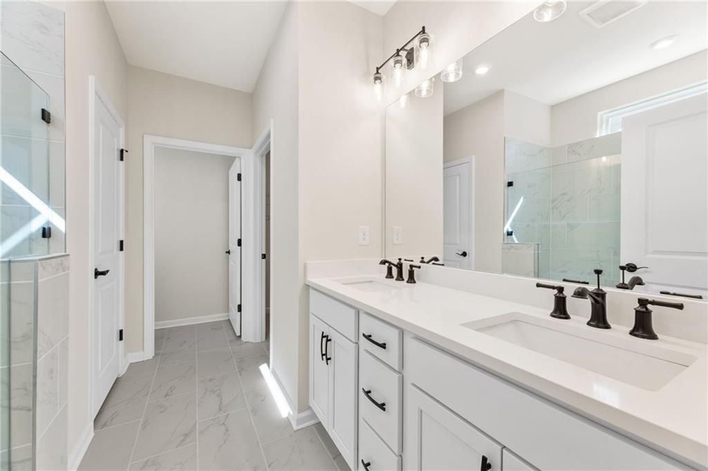 Modern master bathroom featuring double vanity, glass shower enclosure in Davidson Homes The Daphne B, Loganville, GA