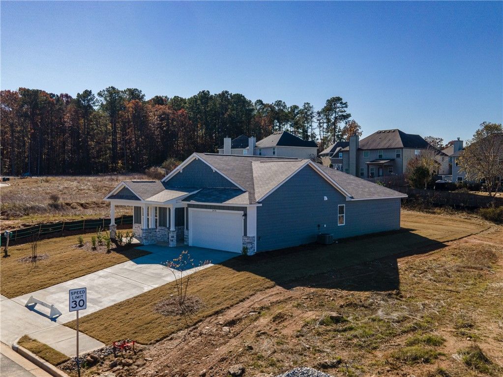 Blue single-story 4-bedroom home with 2-car garage, front porch, and for sale sign in Anderson Lakes, Opelika, Alabama by Davidson Homes The Luna B