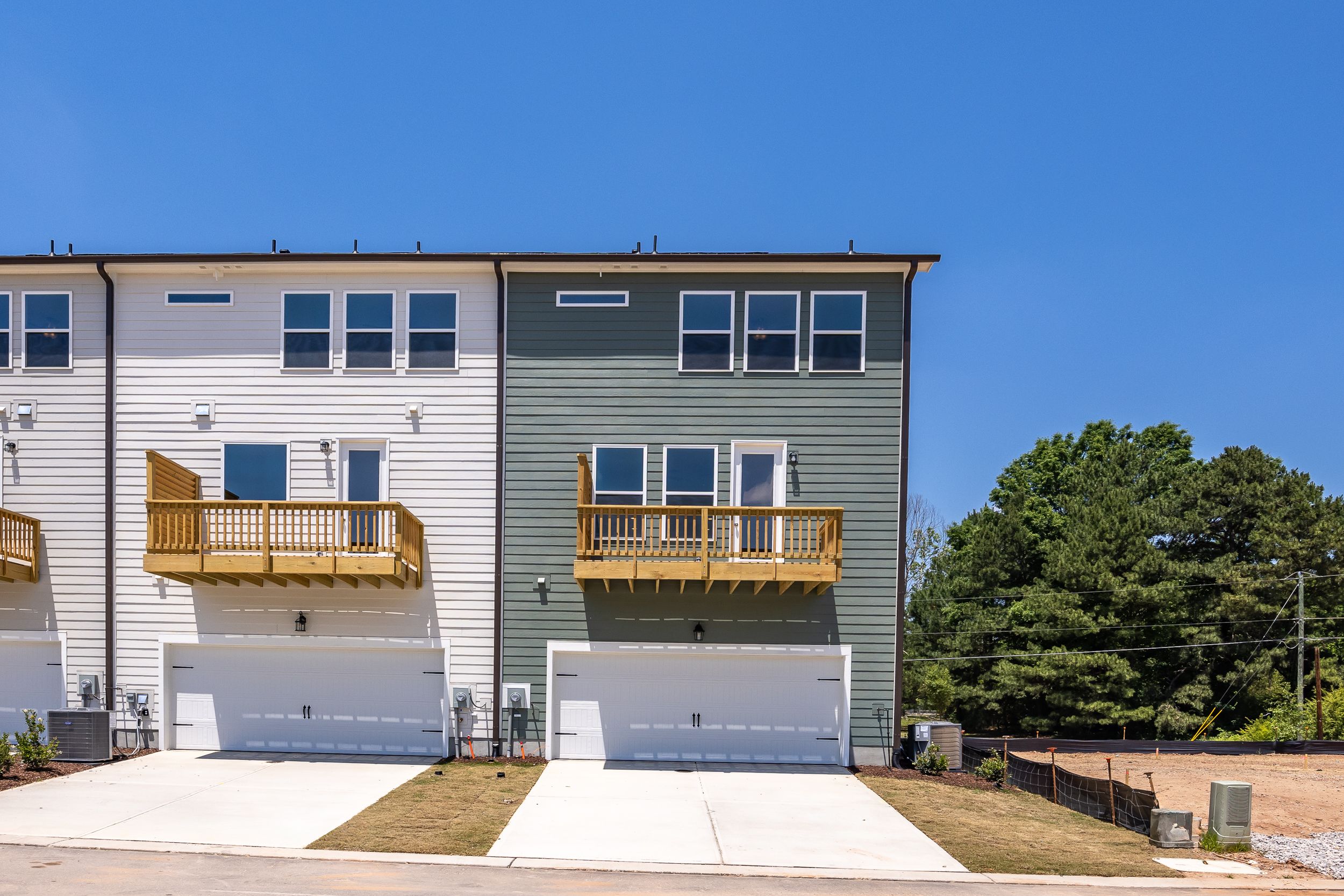 Modern townhome exterior at Summers Walk in Davidson, NC featuring two-car garages and private balconies.