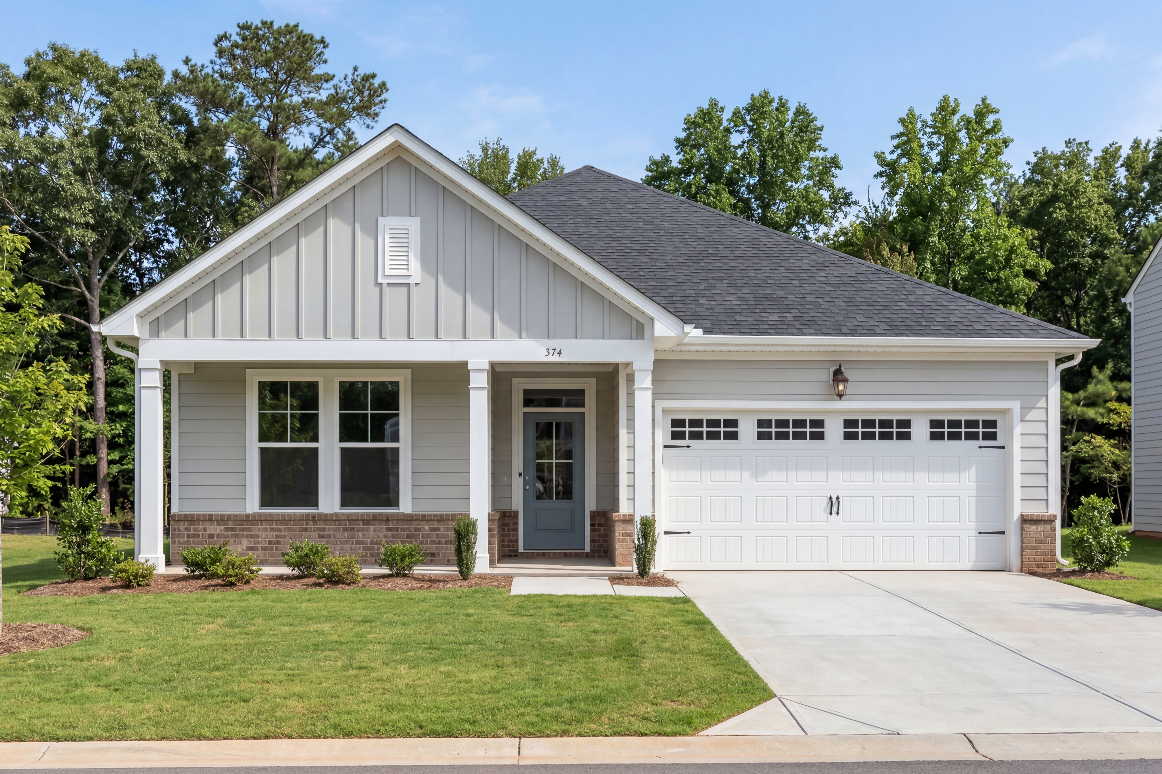 Charming one-story exterior of The Daphne D by Davidson Homes in Mooresville NC with gray siding, front porch, and two-car garage