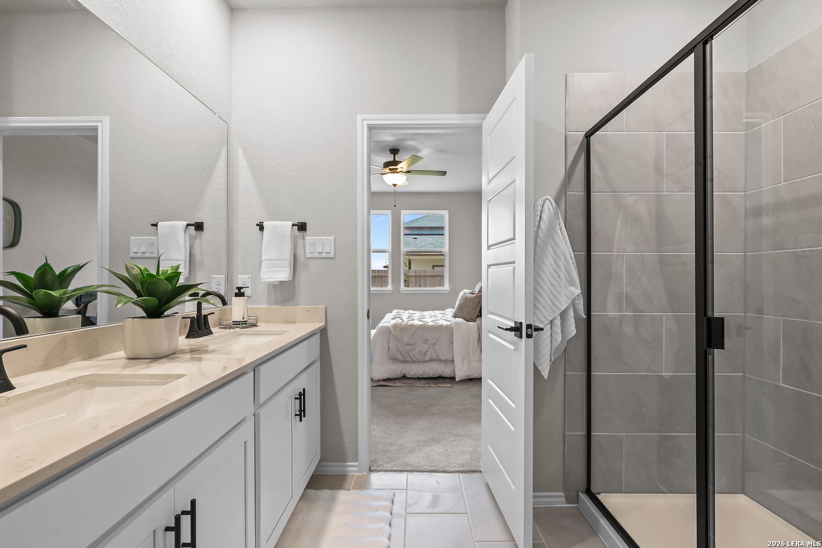 Modern bathroom with double vanity and walk-in glass shower in The Daphne H floor plan, Hannah Heights, Seguin, Texas.