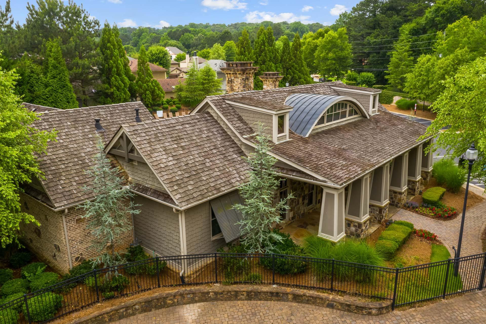 Craftsman home exterior at The Village at Towne Lake in Woodstock GA with shingle roof, stone accents, and wooded landscaping
