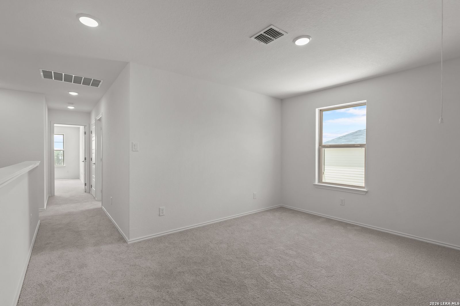 Bright carpeted bedroom with recessed lighting in The Gillian C floor plan by Davidson Homes in San Antonio, Texas.