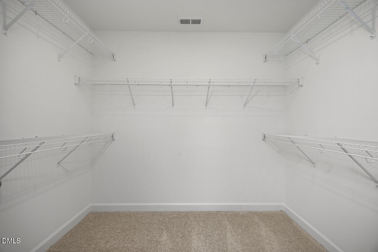 Walk-in closet with white wire shelving in The Adalynn A floor plan at Gregory Village, Lillington, North Carolina.