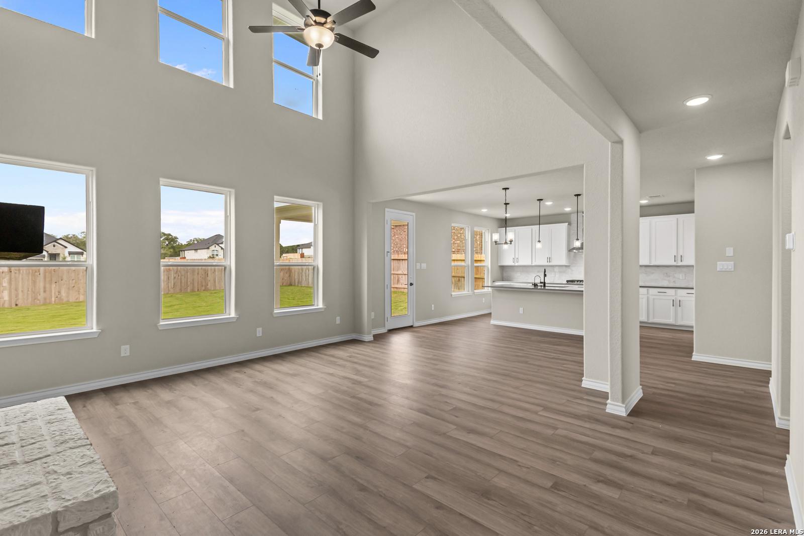 Spacious two-story living room with soaring ceilings and open kitchen in Davidson Homes' The Danbury H, Castroville, TX.