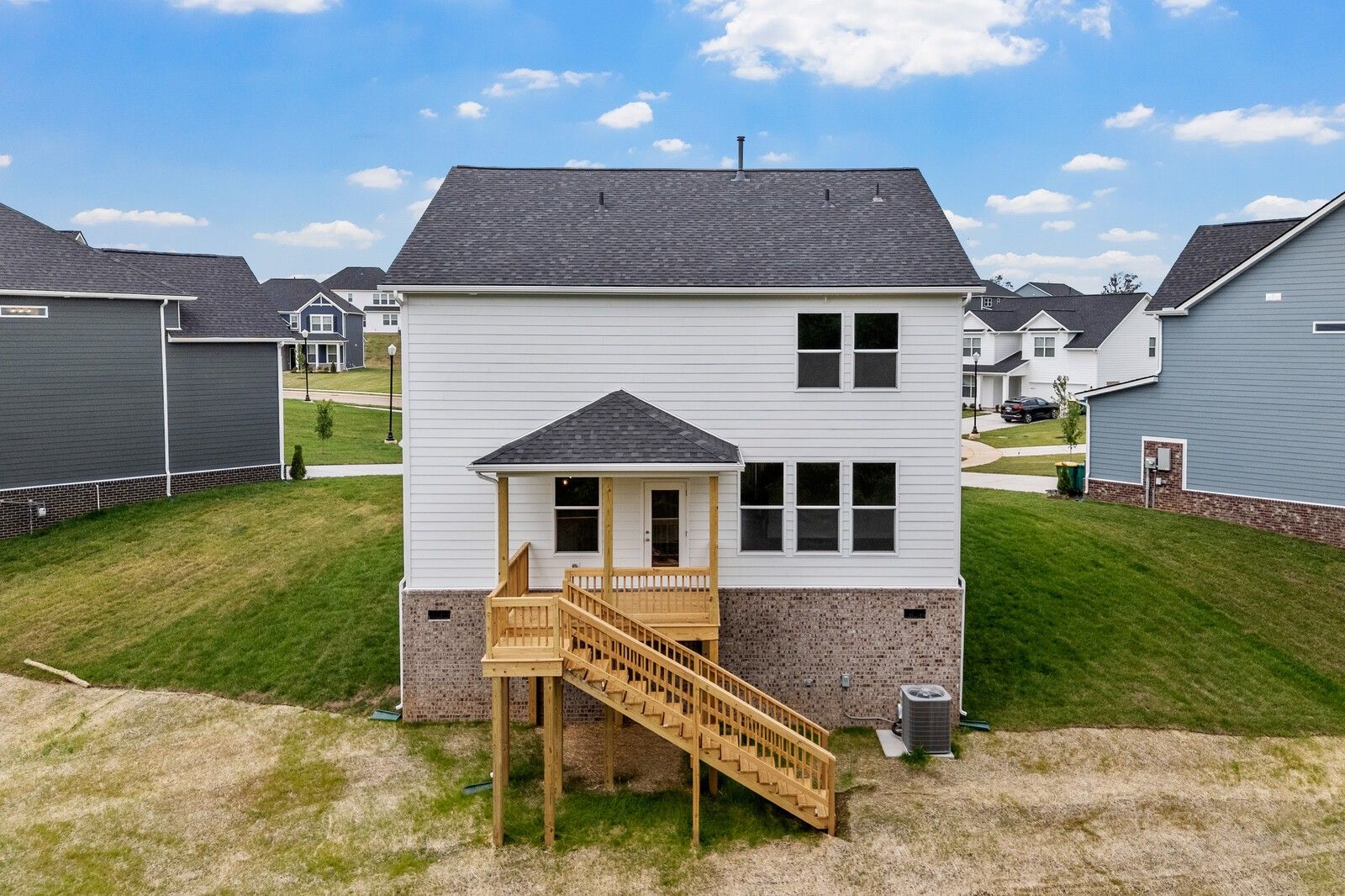 Back exterior view of The Logan C floor plan by Davidson Homes in Calista Farms, White House, Tennessee with wood deck.
