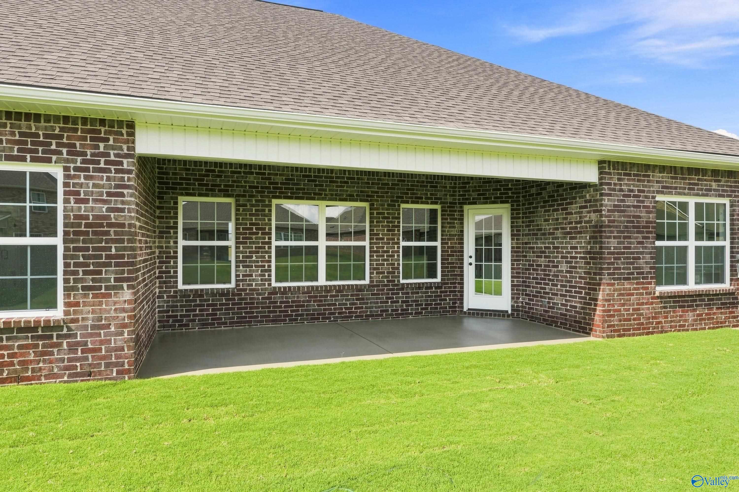 Covered brick patio and backyard of The Rockford B floor plan by Davidson Homes in Kendall Downs, Toney, Alabama.