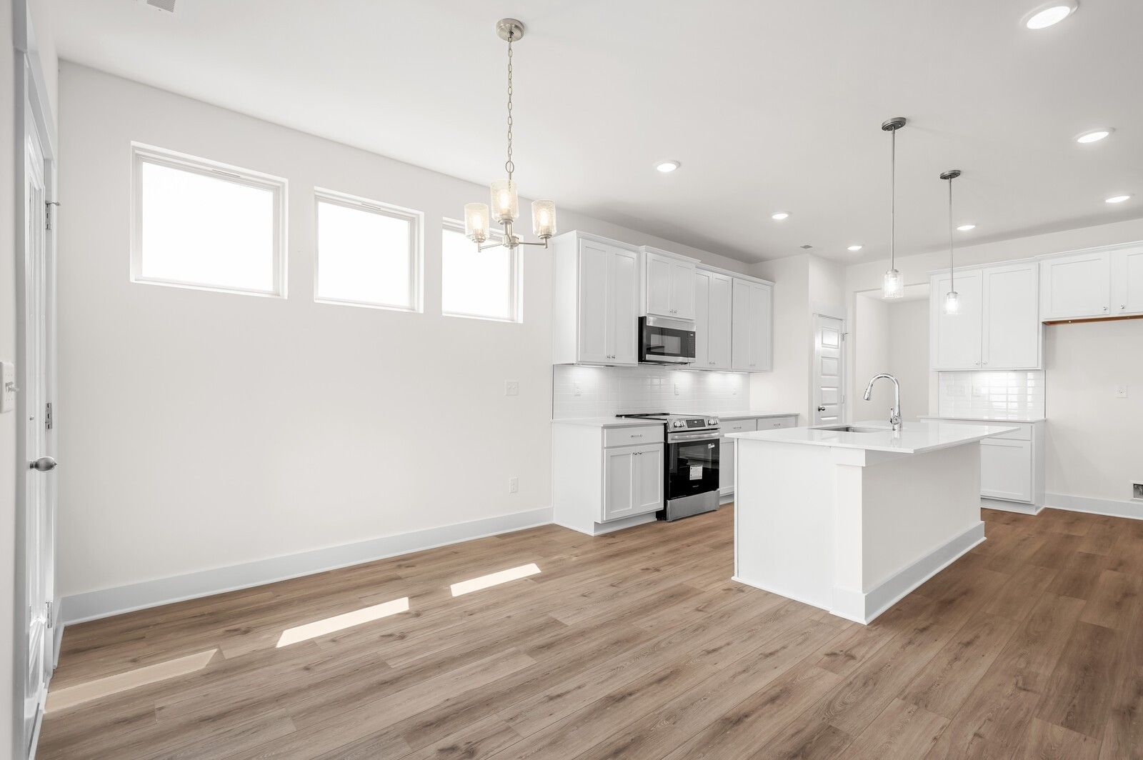 Modern open-concept kitchen and dining area in The Ash A floor plan by Davidson Homes in Woods Crossing, Gallatin, TN.