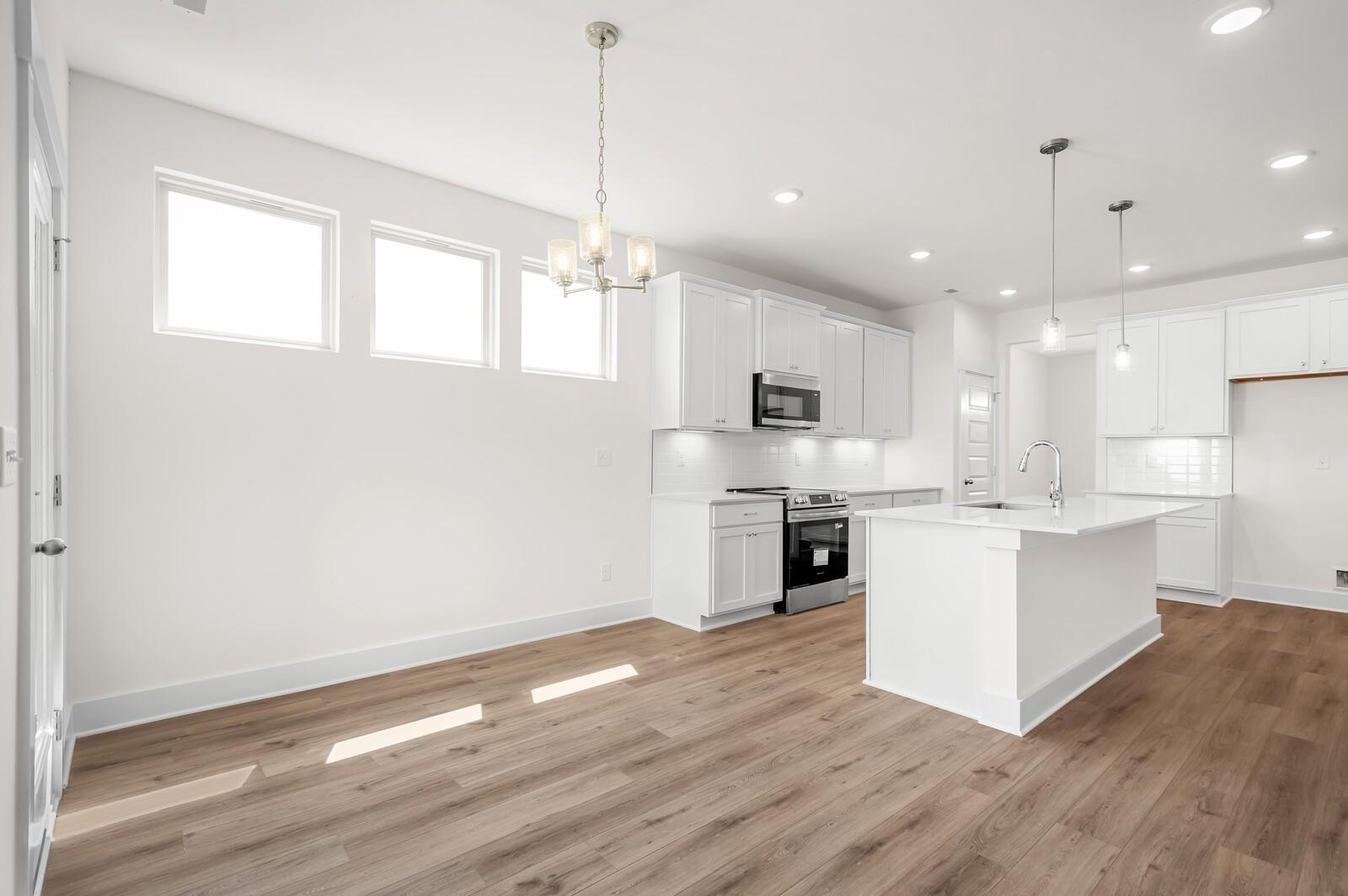 Modern open-concept kitchen and dining area in The Ash A floor plan by Davidson Homes in Woods Crossing, Gallatin, TN.