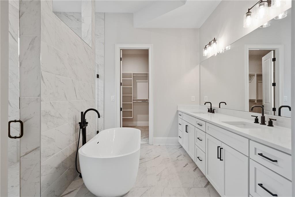 Luxurious master bath with freestanding soaking tub, double vanity, and marble accents in Davidson Homes The Seaside B, Woodstock, GA