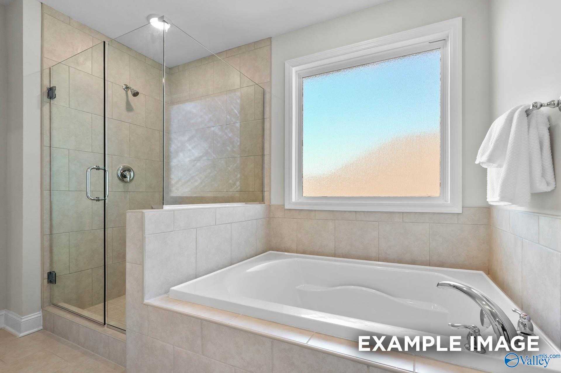 Luxurious master bathroom with frameless glass shower and soaking tub in Davidson Homes The Madison A, Harvest, AL