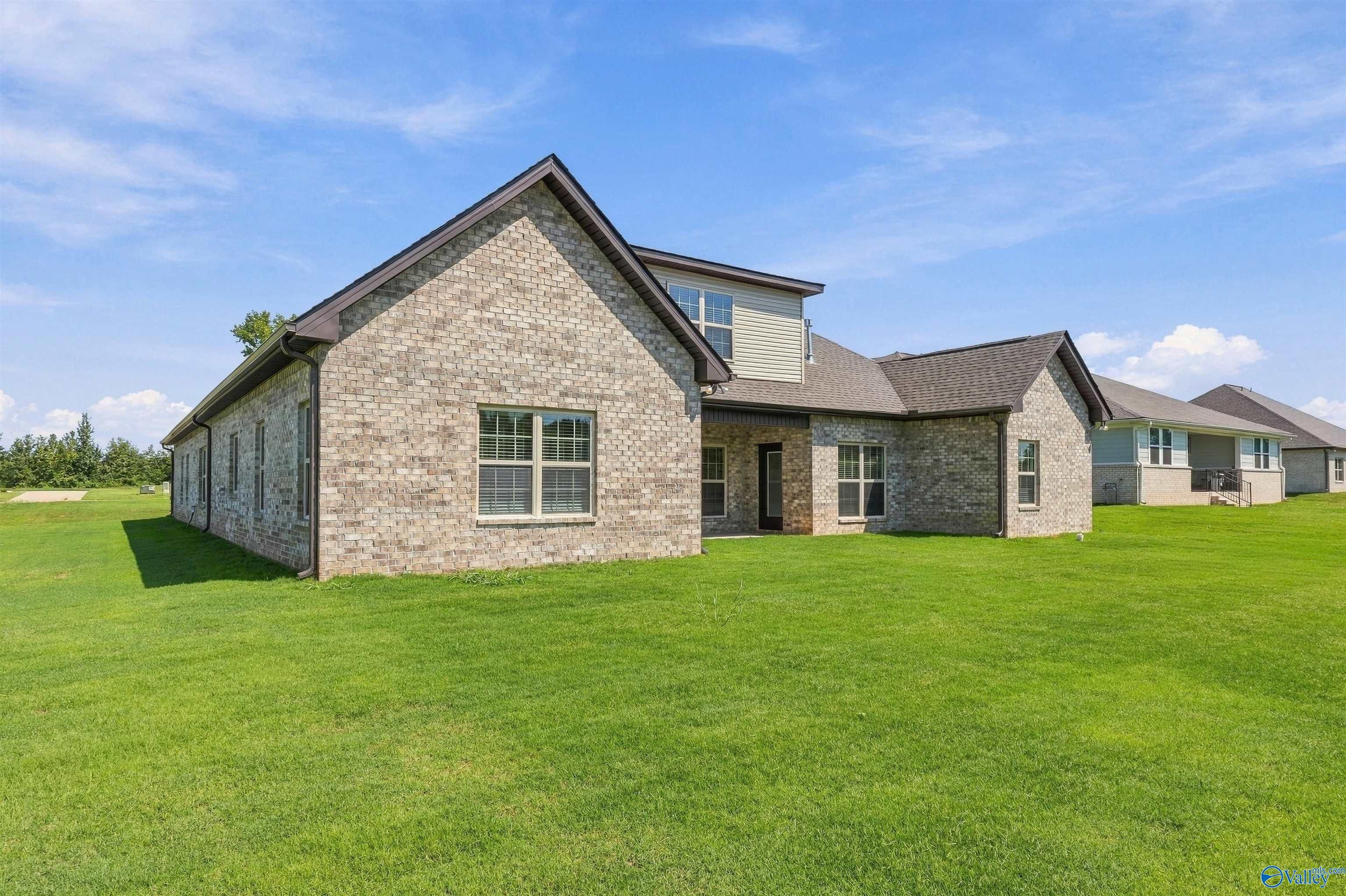 Brick rear exterior with gabled roofline and expansive green lawn at Davidson Homes' The Valencia in Riverton Preserve, Huntsville