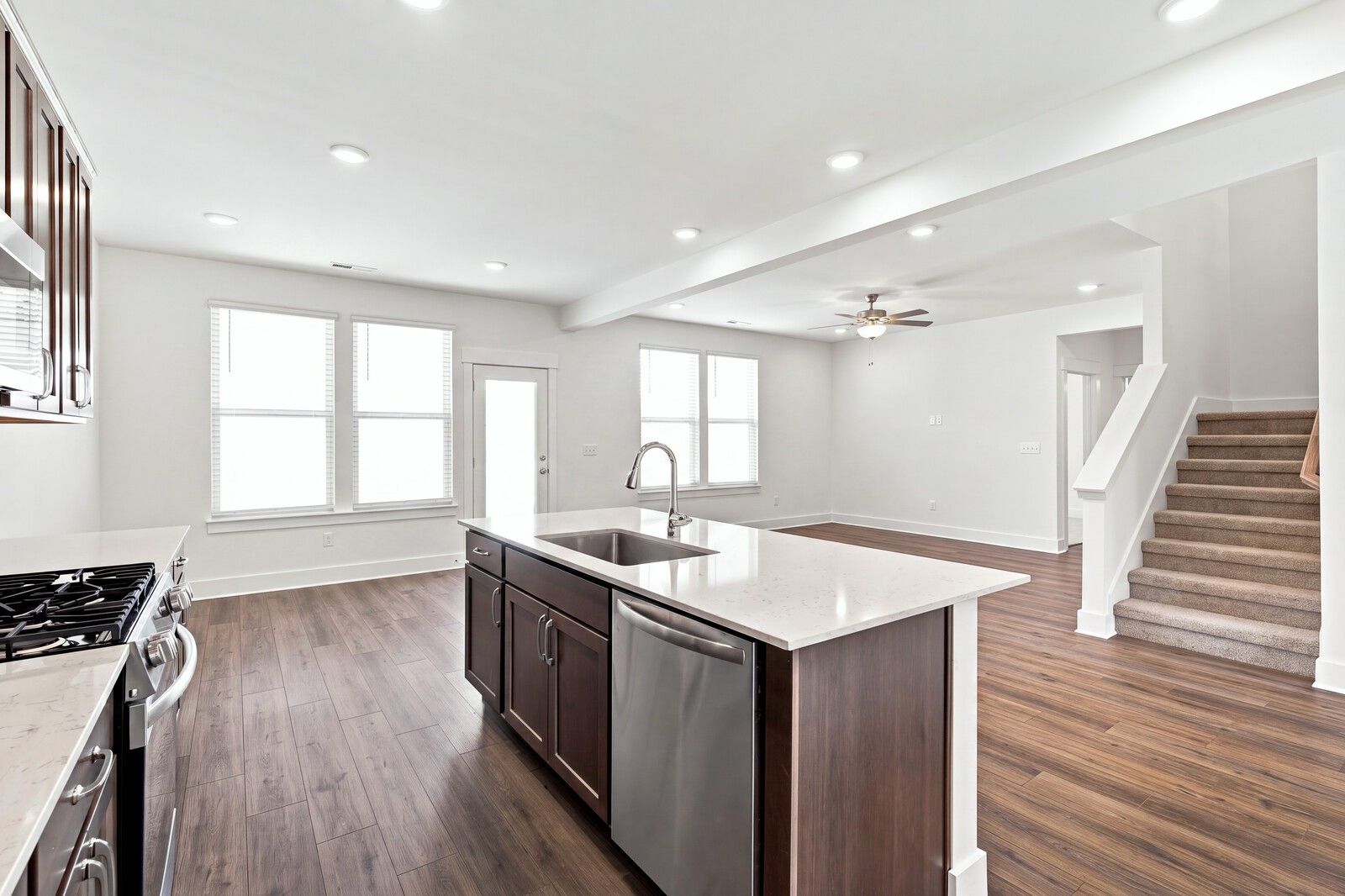 Open-concept kitchen with island sink and dark wood cabinets flowing into great room in Davidson Homes Willow C, Gallatin TN