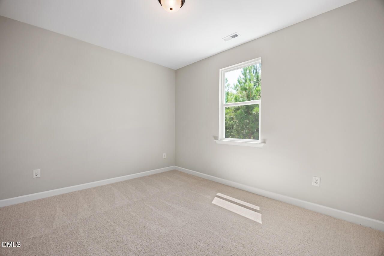 Spacious bedroom with neutral carpet and natural light in The Chestnut floor plan by Davidson Homes in Montrose, Aberdeen.