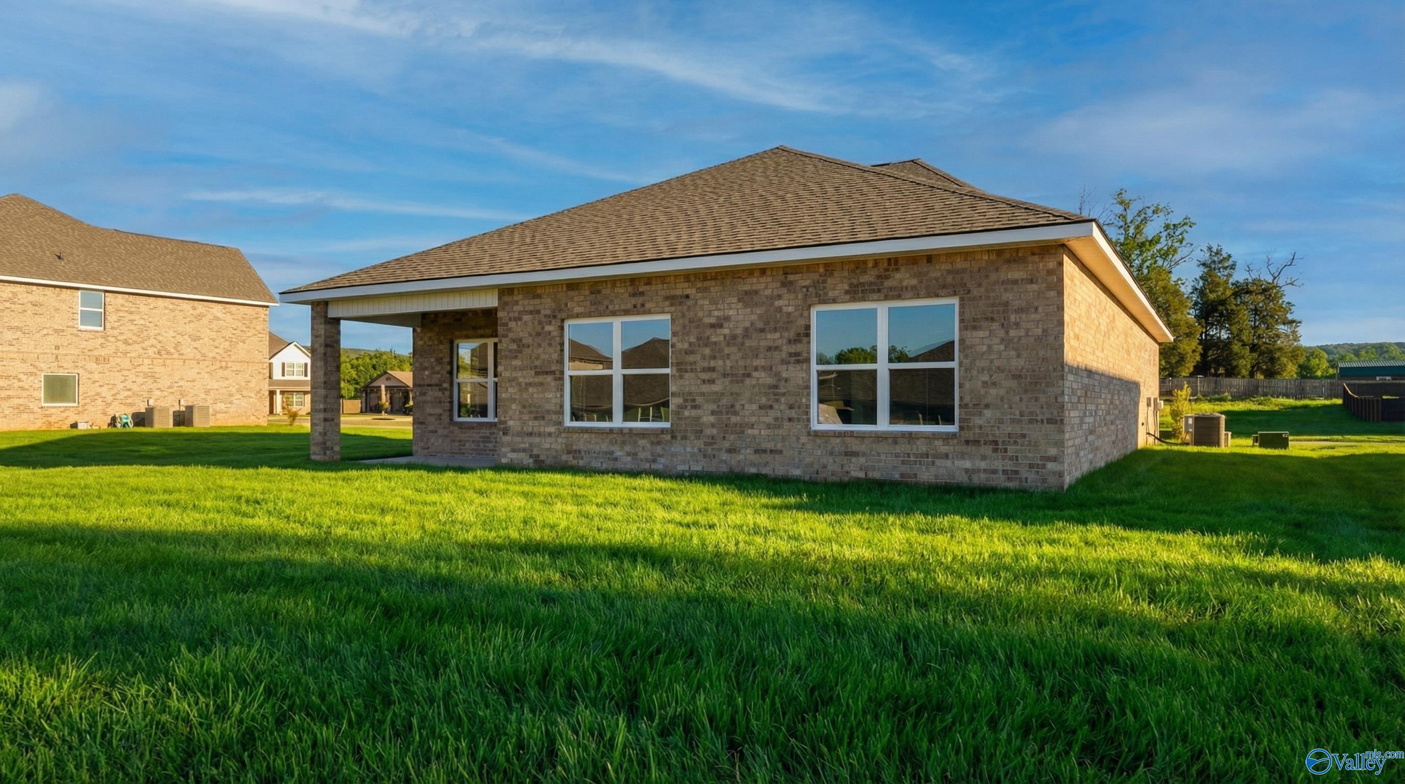Single-story brick home with covered porch, large windows, and lush green yard in Creek Grove, New Market, Alabama - Davidson Homes The Franklin C