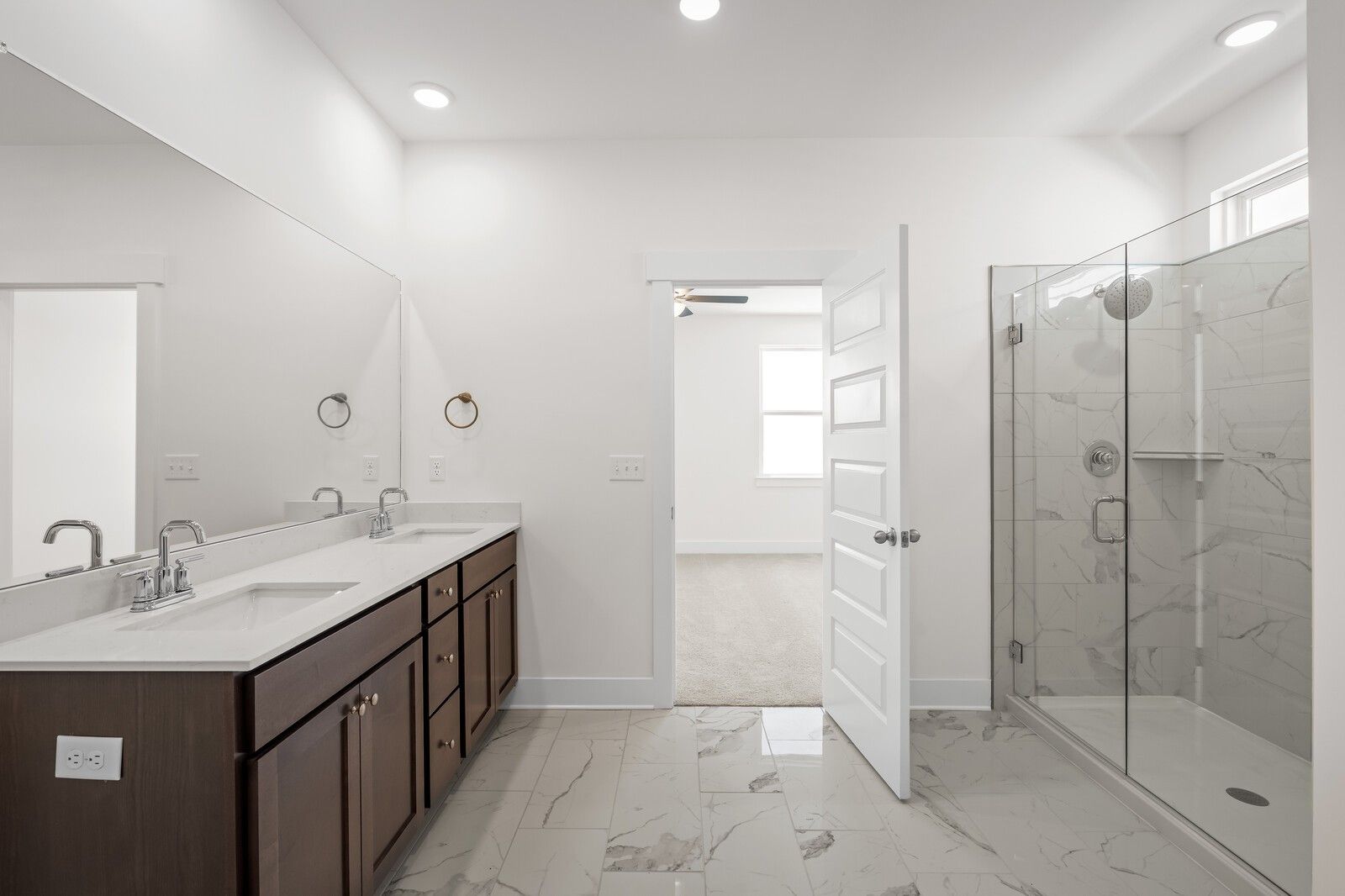 Modern master bathroom with dual vanity and walk-in glass shower in The Cottonwood E home at Woods Crossing, Gallatin, TN.