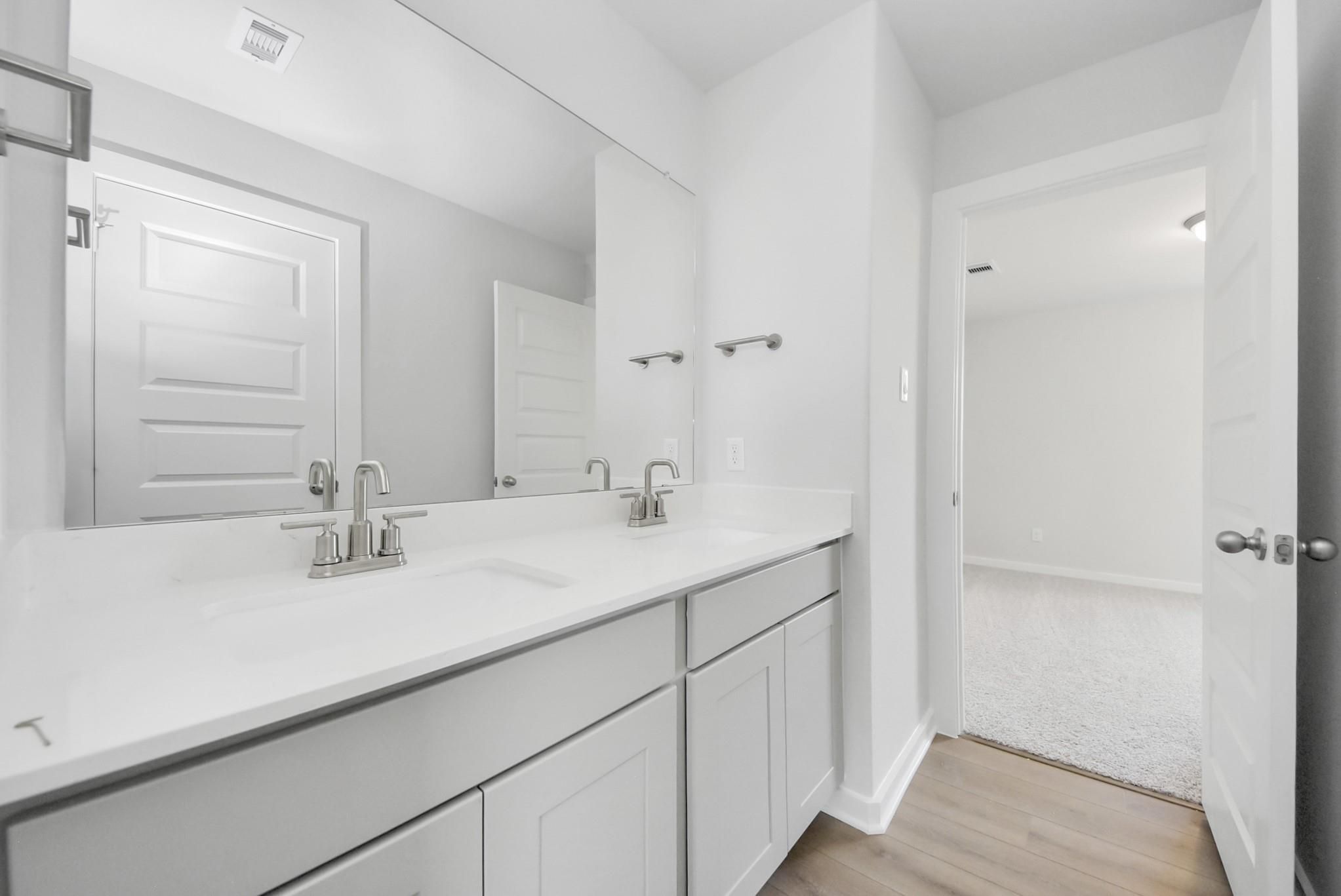 Modern double-vanity bathroom in The Verano B floor plan by Davidson Homes at Sunterra in Katy, Texas.