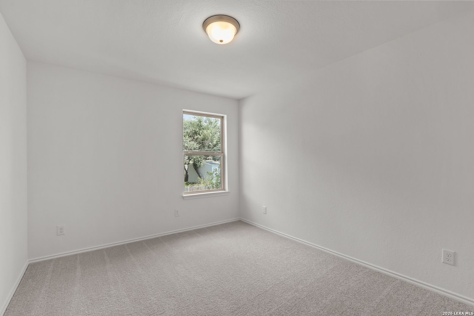 Bright bedroom with neutral carpet and window view in The Gillian C floor plan by Davidson Homes, San Antonio, Texas.