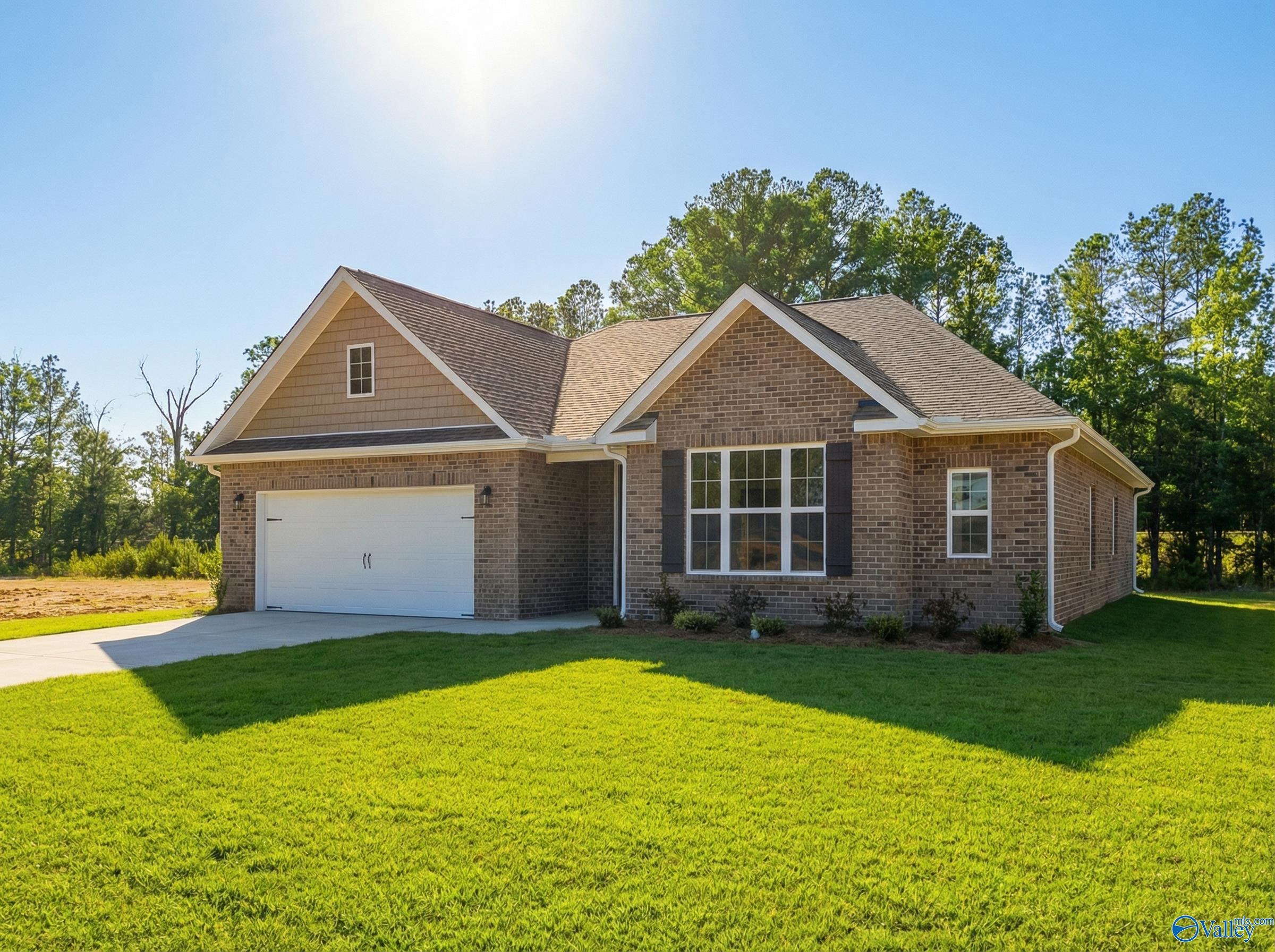 Modern brick ranch home with 2-car garage, gabled roof, and green lawn in Cain Park, Hartselle, Alabama - Davidson Homes Montgomery B