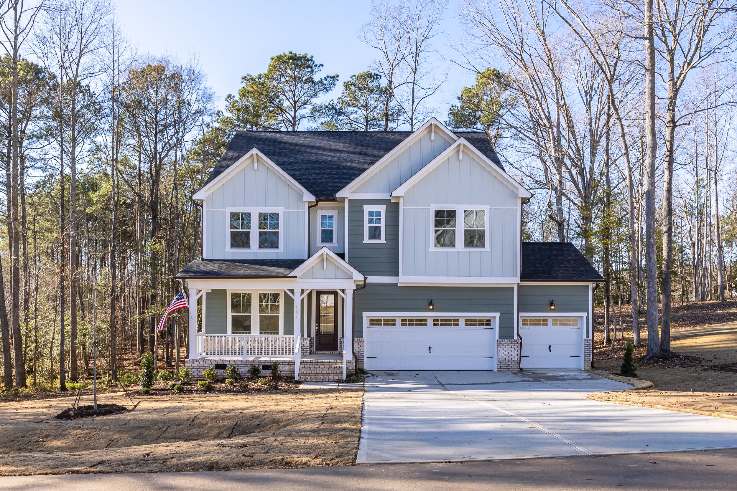 Two-story home exterior at Rockport in Wake Forest, NC by Davidson Homes with a covered porch and three-car garage.