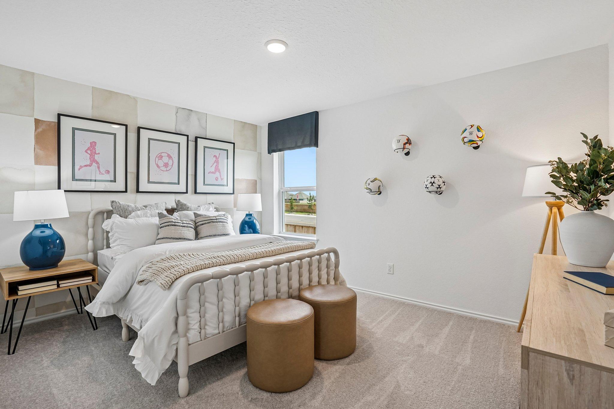 Spacious bedroom at Morgan Meadows in San Antonio with soccer-themed decor, spindle bed frame, and modern furniture.