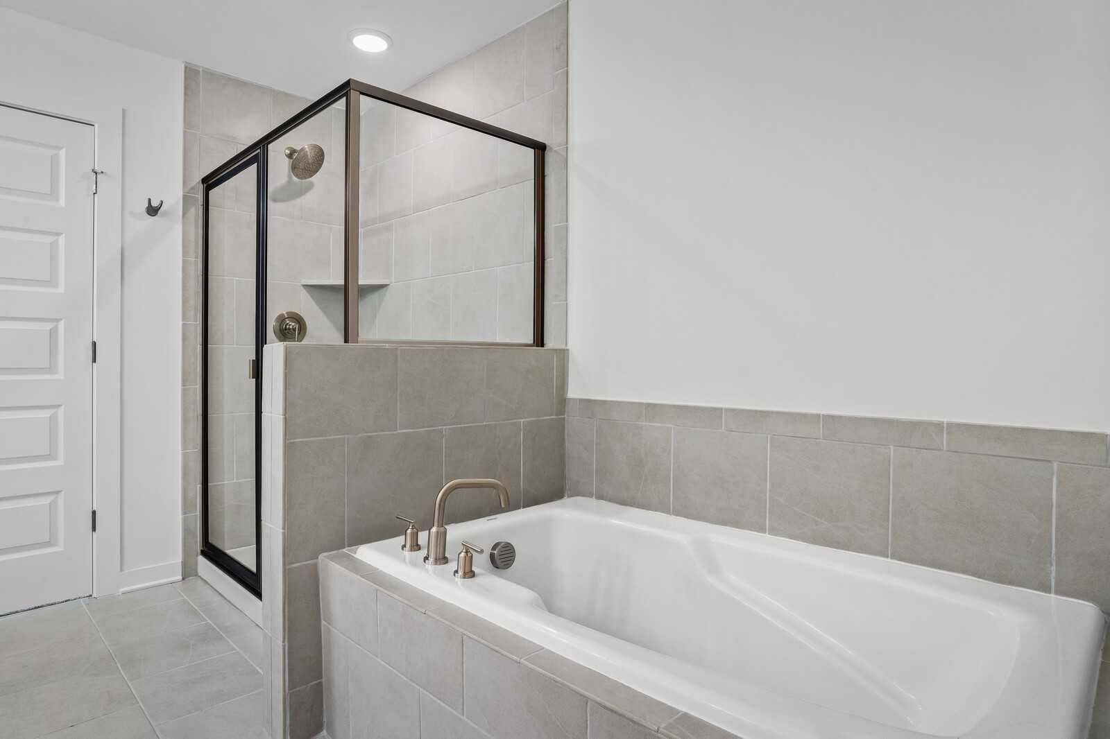 Modern master bathroom with frameless glass shower and jetted soaking tub in Davidson Homes The Logan B, Calista Farms, White House, TN