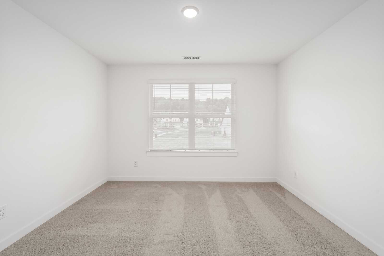 Bright secondary bedroom with white walls, beige carpet, and window blinds in 4BR Davidson Homes Ridgeport, Gallatin TN
