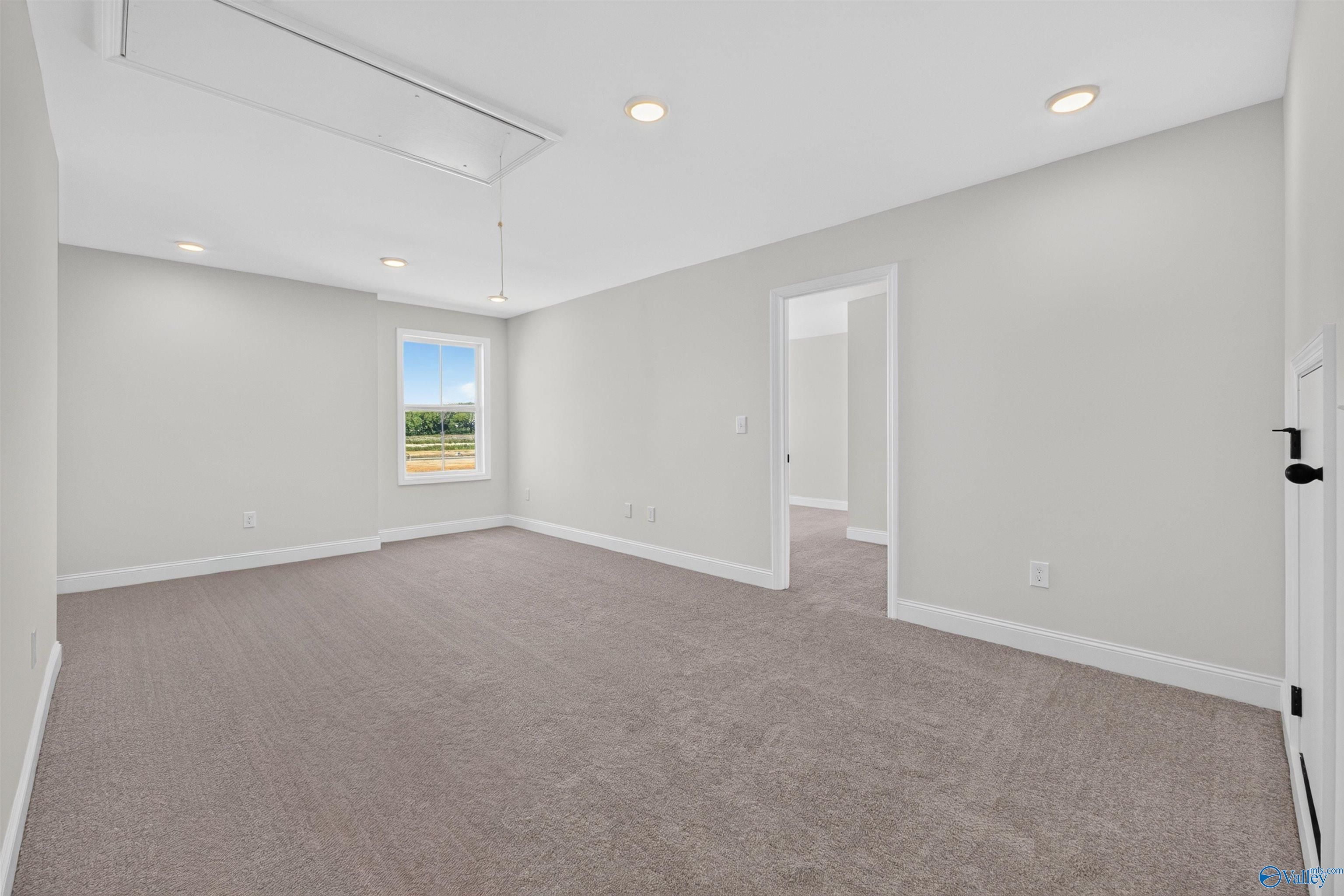 Spacious carpeted bedroom with recessed lighting and window view in Davidson Homes Ashport L floor plan, Berry Cove, New Market, Alabama