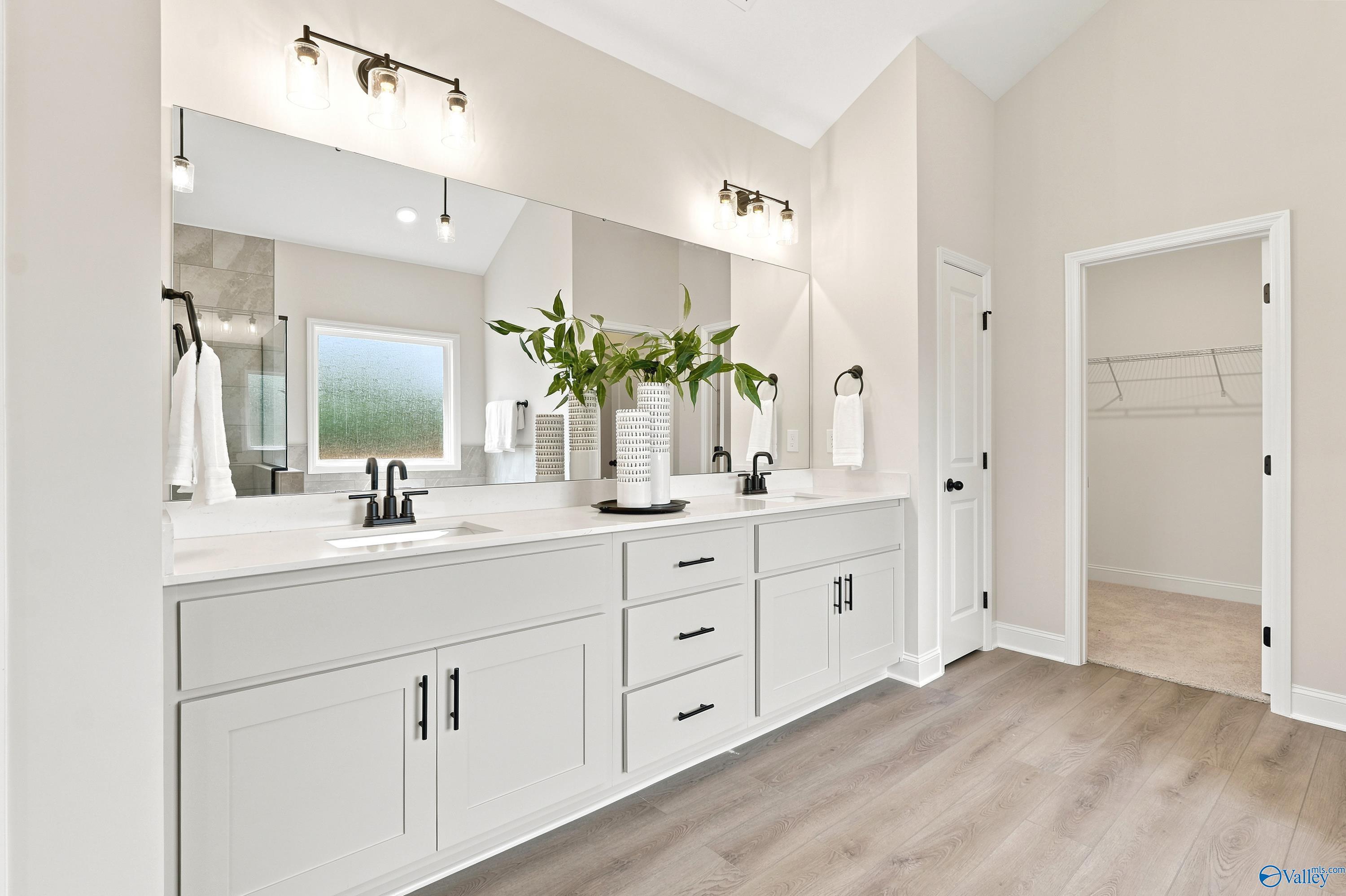 Modern master bathroom with dual vanity and walk-in closet in The Finleigh floor plan at Riverton Preserve, Huntsville.