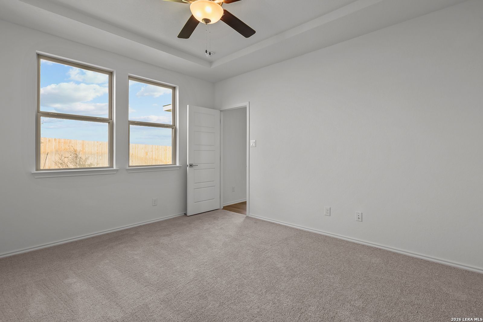 Spacious bedroom with tray ceiling and carpet in The Brazos B floor plan by Davidson Homes in Agave, San Antonio, Texas.