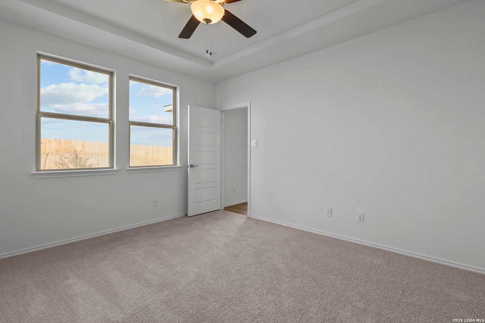 Spacious bedroom with tray ceiling and carpet in The Brazos B floor plan by Davidson Homes in Agave, San Antonio, Texas.