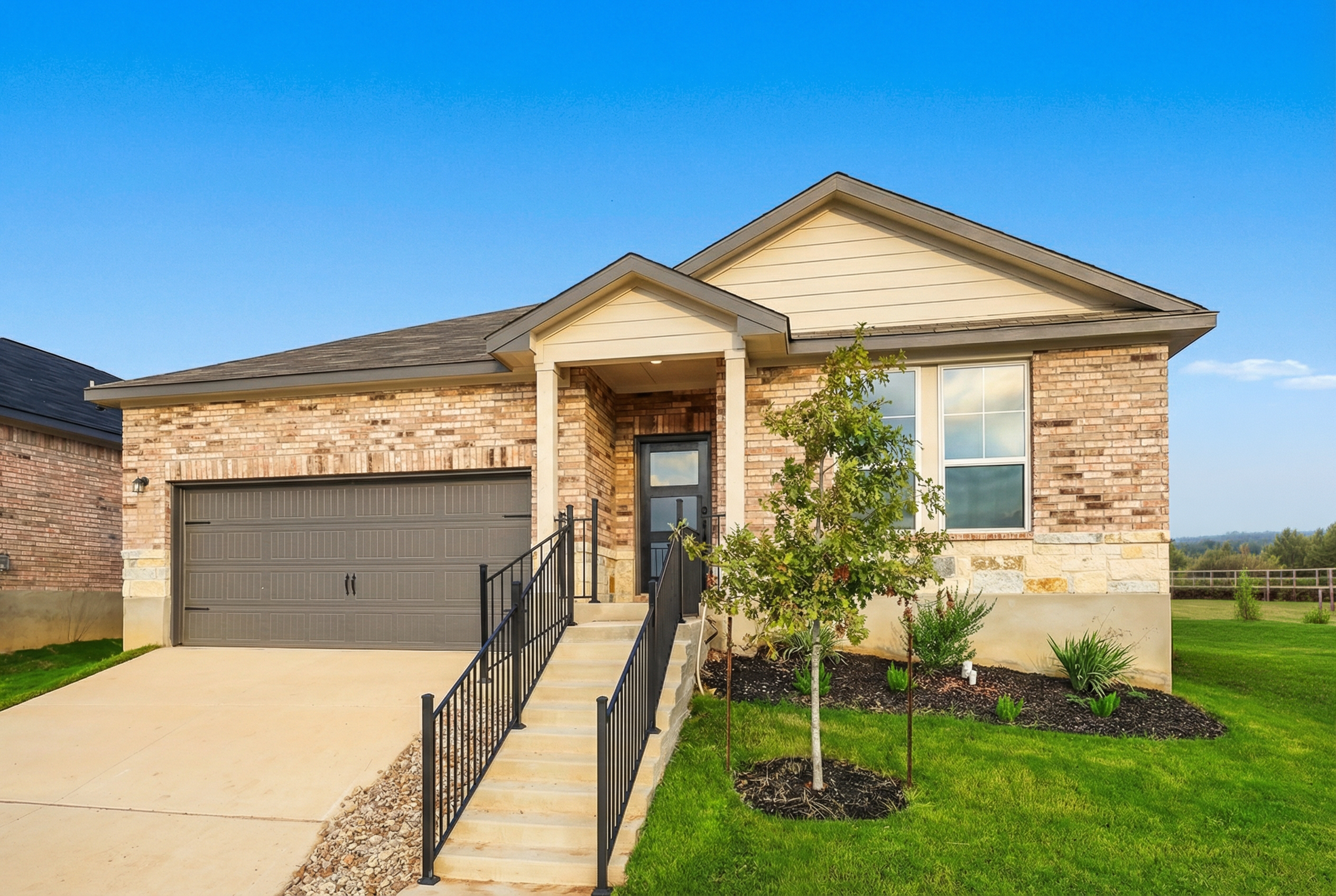 Modern brick home exterior in Heartland Texas by Davidson Homes with covered front porch, garage, and landscaped yard