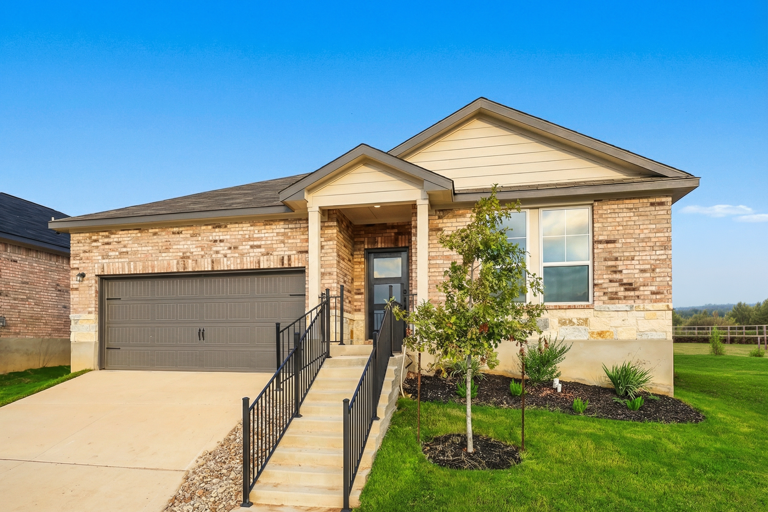Modern brick home exterior in Heartland Texas by Davidson Homes with covered front porch, garage, and landscaped yard