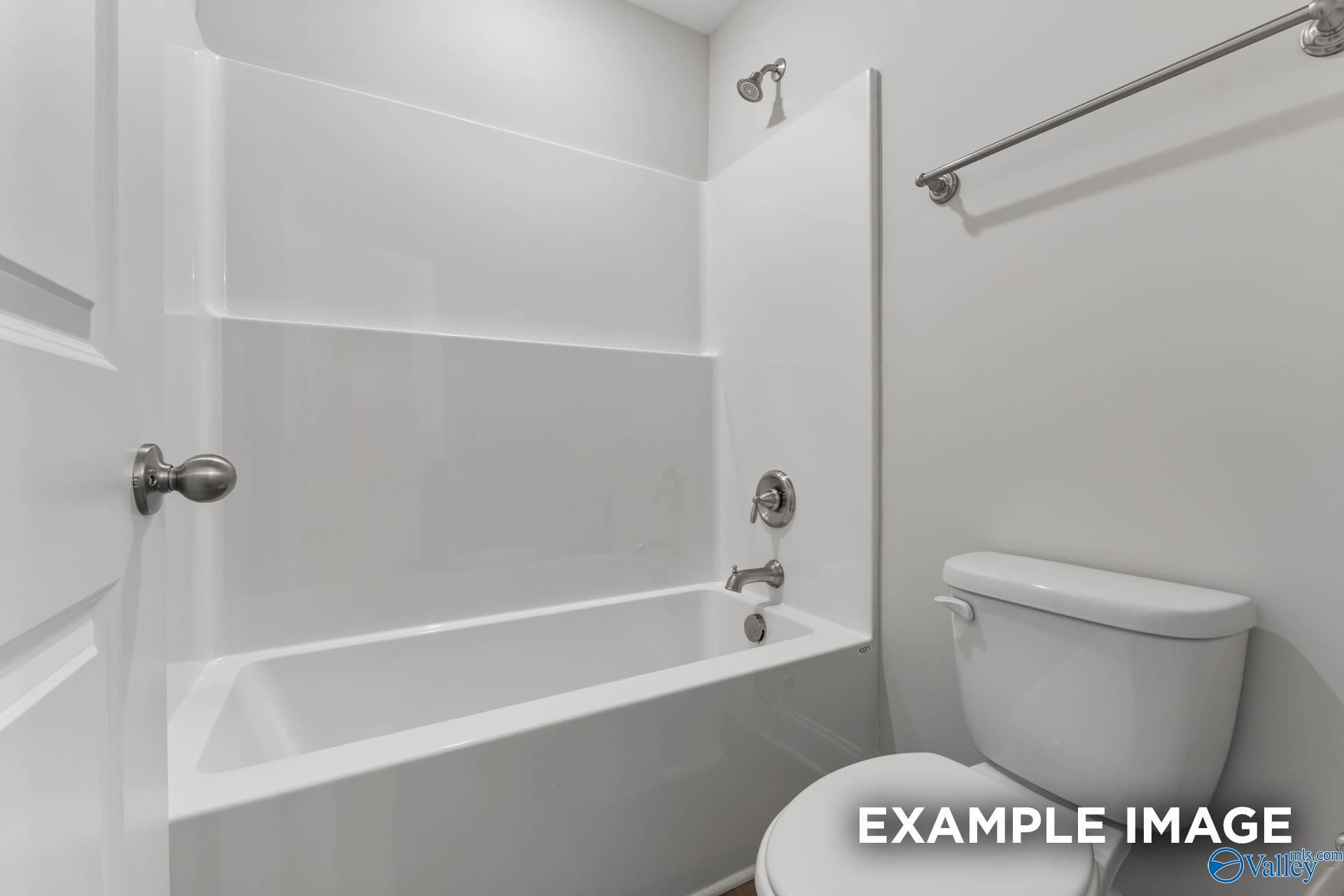 Bright white bathroom with tub-shower combo, modern toilet in Davidson Homes Chelsea D, New Market, Alabama