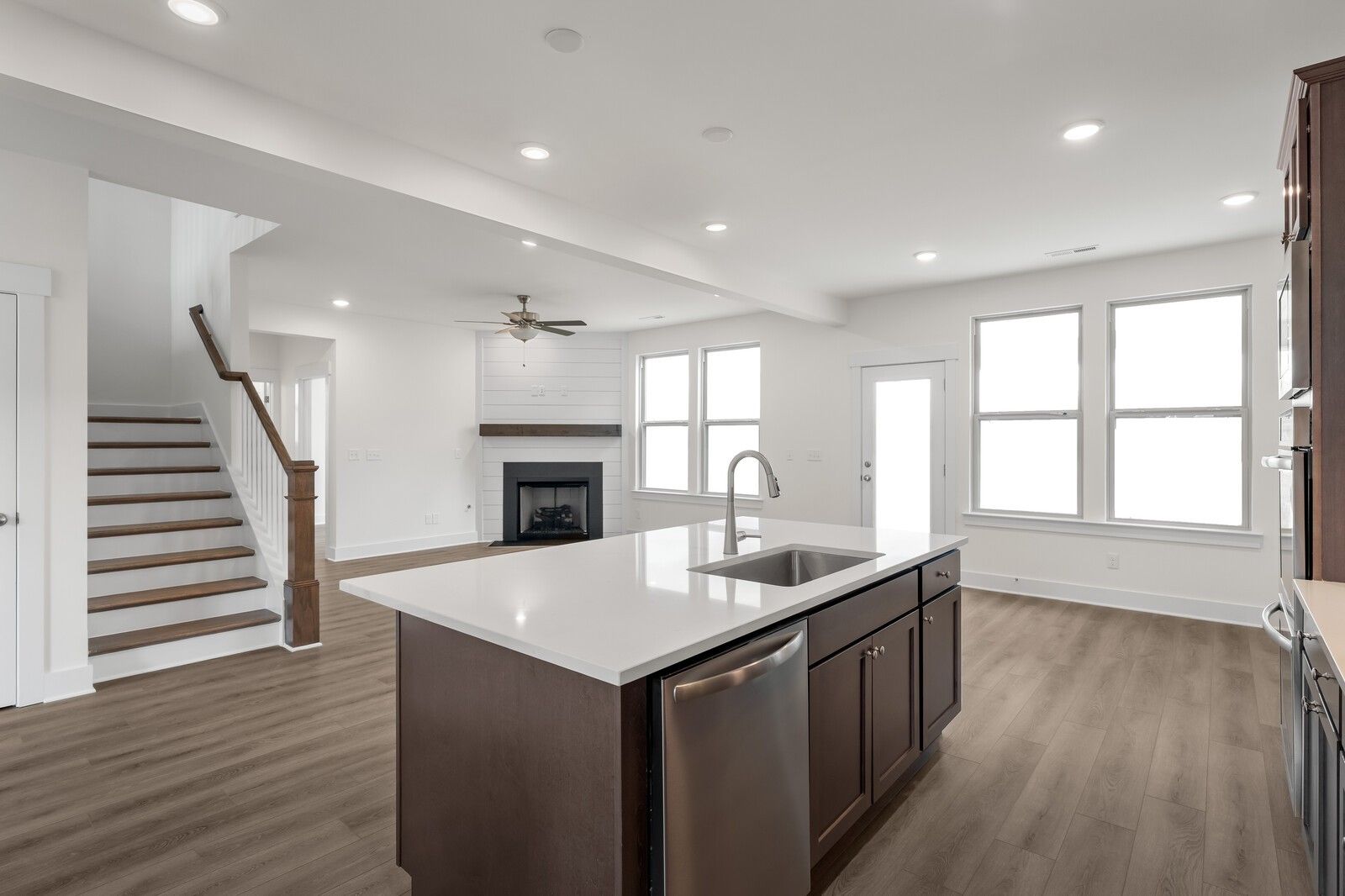 Open-concept kitchen with white quartz island, stainless sink, and dark cabinets in Davidson Homes The Willow C, Gallatin, TN