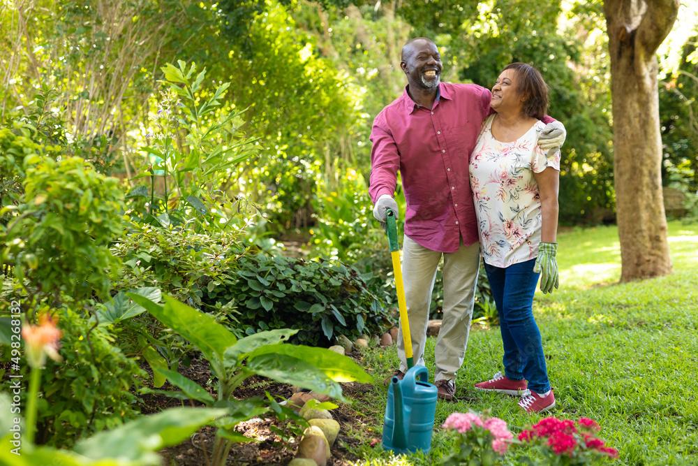Happy senior couple gardening in lush backyard with vibrant plants at The Villas at Barnett's Crossing in Madison, Alabama