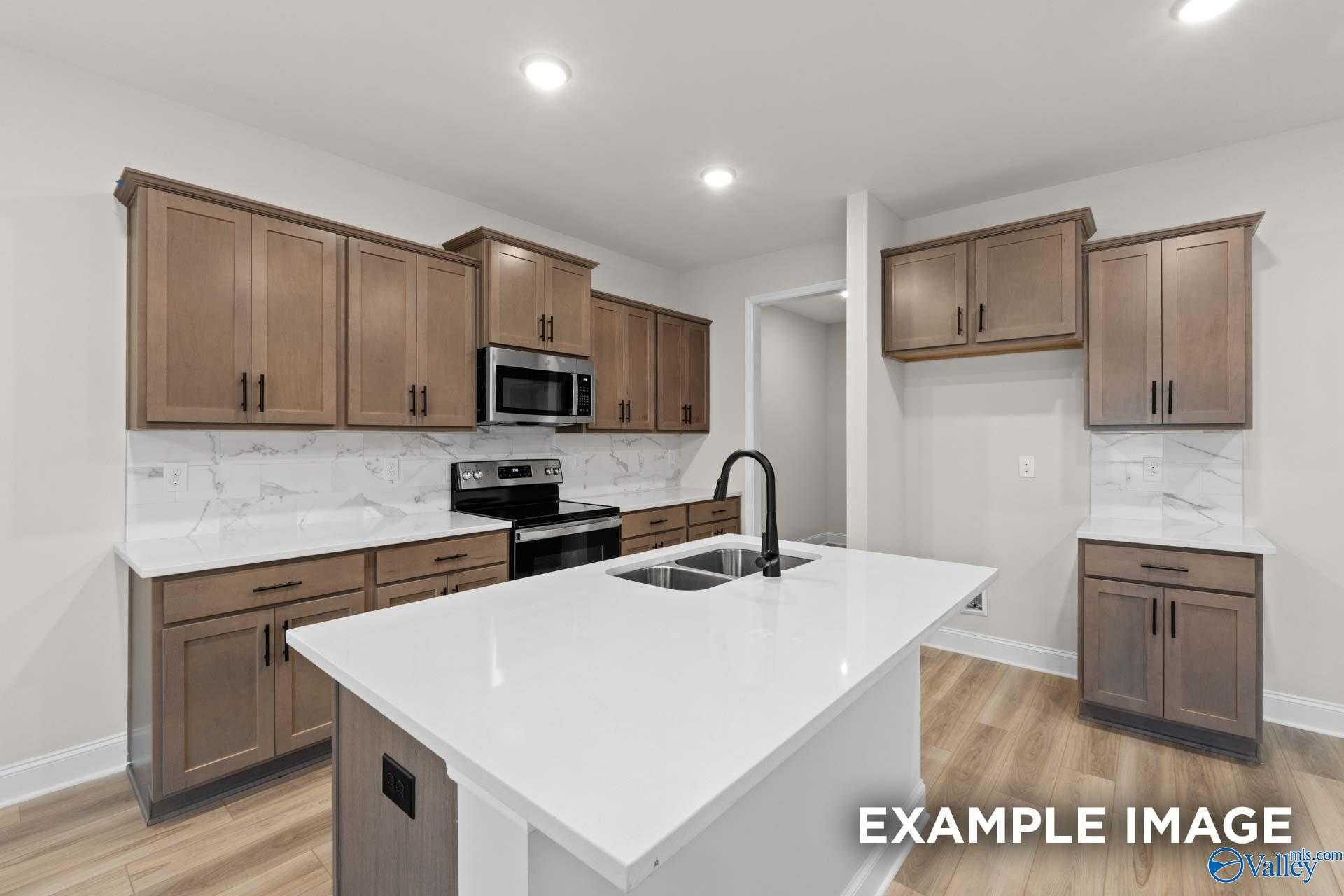 Modern kitchen featuring shaker cabinets, white quartz island, stainless steel appliances in The Camden D by Davidson Homes, Huntsville AL