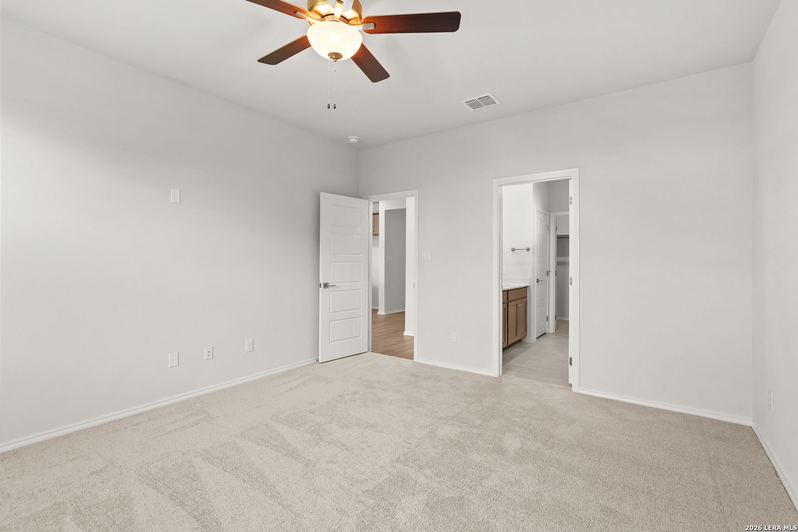 Bright carpeted bedroom with ceiling fan and ensuite bath access in Davidson Homes The Daphne I, Bricewood, San Antonio, TX