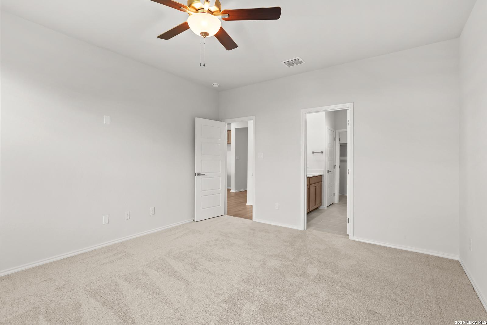 Bright carpeted bedroom with ceiling fan and ensuite bath access in Davidson Homes The Daphne I, Bricewood, San Antonio, TX