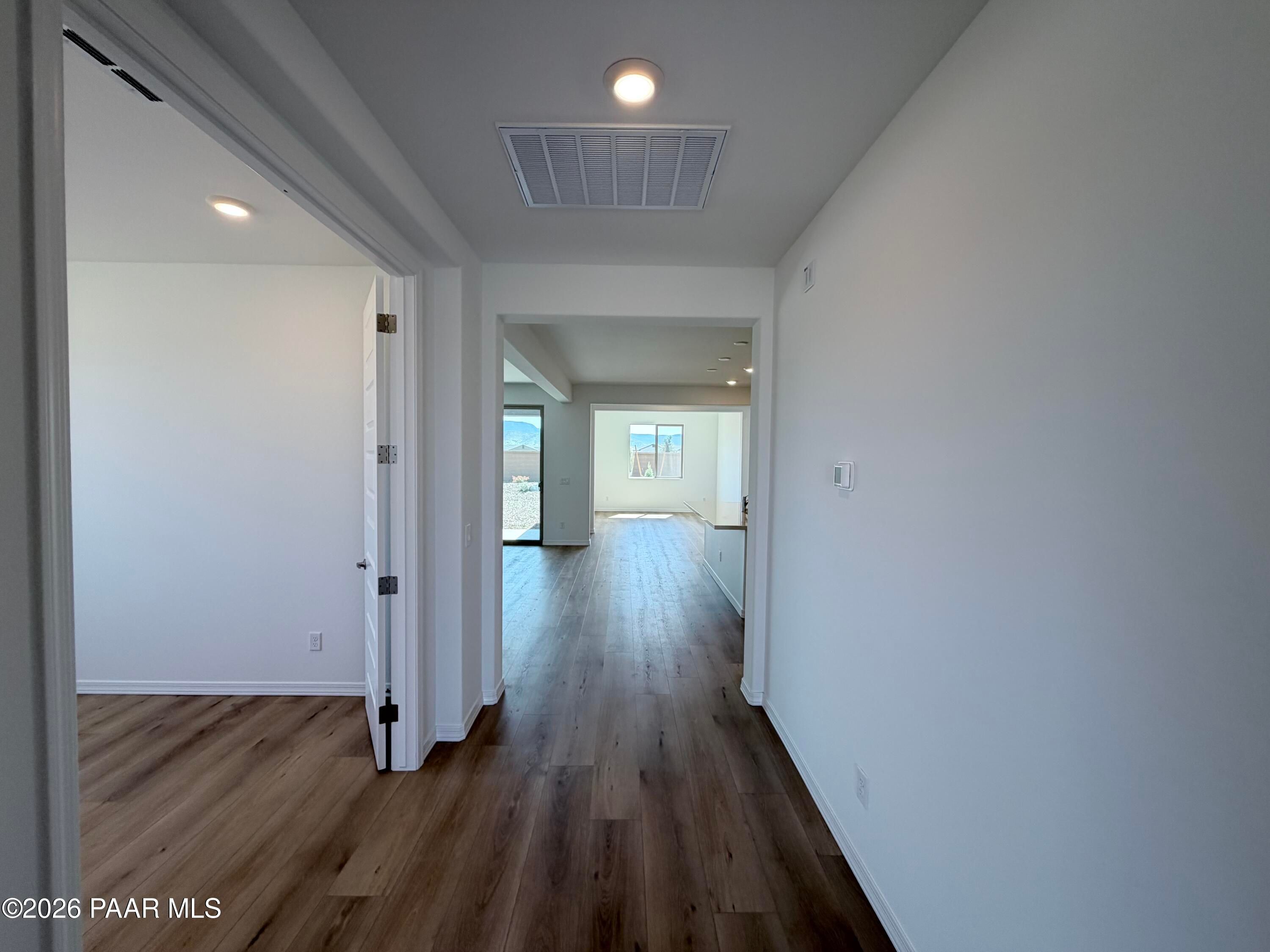 Bright hallway with wood-look flooring leading to an open-concept living area in a Davidson Homes floor plan, Prescott Valley.