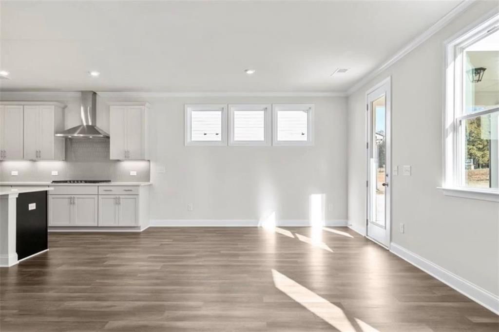 Bright open-concept kitchen and dining area in The Ash C floor plan at Wehunt Meadows in Hoschton, Georgia.