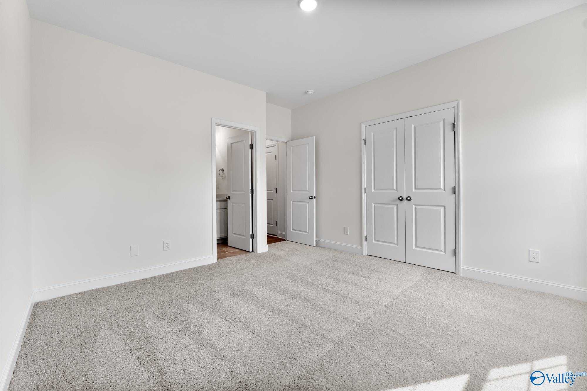 Bright master bedroom with walk-in closet and en suite bathroom in Davidson Homes The Harrison, Meridianville, Alabama